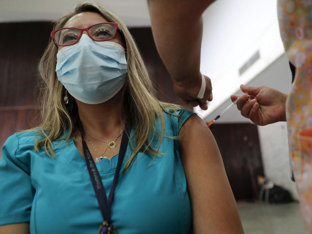 A health worker receives a dose of the Pfizer vaccine in Chile. Picture: Javier Torres/AFP