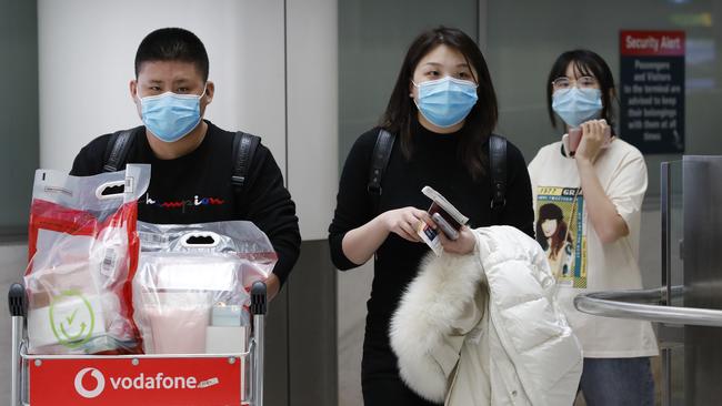 Masks at Sydney Airport. People Wearing Masks due to Coronavirus walk out of Customs after arriving in Sydney from Shanghai this afternoon. Picture: CHRIS PAVLICH