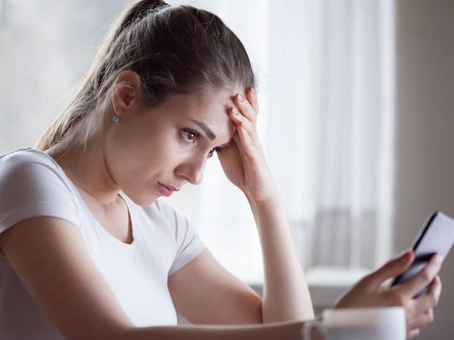 Angry young woman looking at smartphone frustrated by no signal or scam message, mad female disappointed by bad news reading on phone, upset girl get negative or rejection response on mobile; generic scam