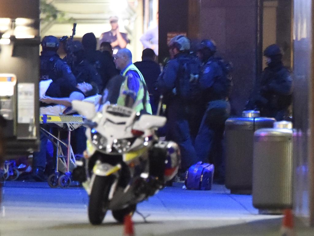 Heavily armed police outside the Lindt shop in Martin Place as an injured hostage is taken to hospital. Picture: Gordon McComiskie