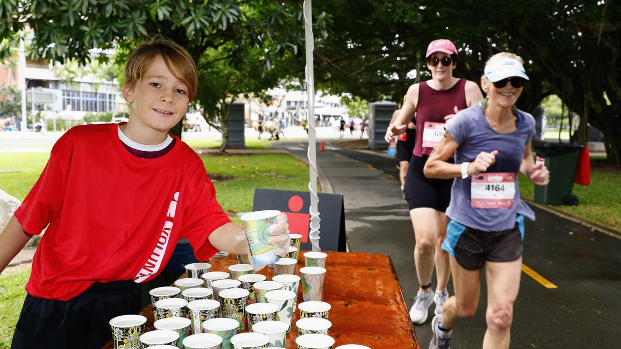 Jara Mead, 11, hands out water for the triathletes on the run leg at the Ironman Cairns race. Picture: Brendan Radke