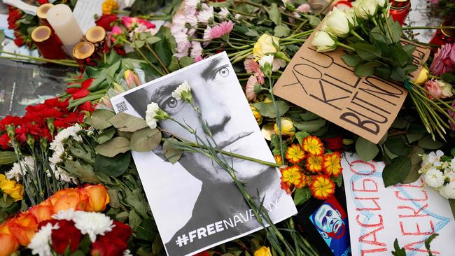 People lay flowers and candles at a memorial in front of the Russian embassy in Berlin, following the death of the Kremlin's most prominent critic Alexei Navalny in an Arctic prison.