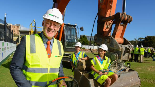 South Australian tennis great John Fitzgerald serves up the start of the Memorial Drive redevelopment with junior players Felicity Ward and Aaliyah Giang. Picture: Brenton Edwards/AAP