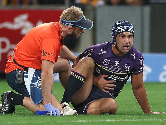 Jahrome Hughes of the Storm is attended to by a trainer after his collision with Nathan Cleary. Picture: Getty Images