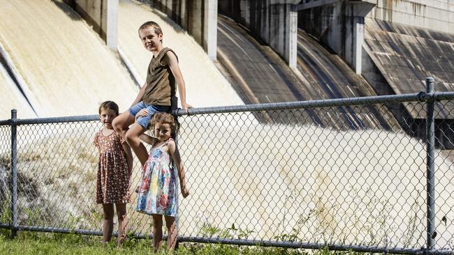 Abby 7, Emily 5, and Jack Latham 9, watch Leslie Dam overflowing at Warwick as it reached capacity for the first time in their life, bringing much needed water security to the region. Picture Lachie Millard