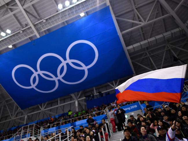 A spectator waves a Russian flag in front of The Olympic Rings. The IOC said Russia’s sanctions were “different situations”. Picture: AFP