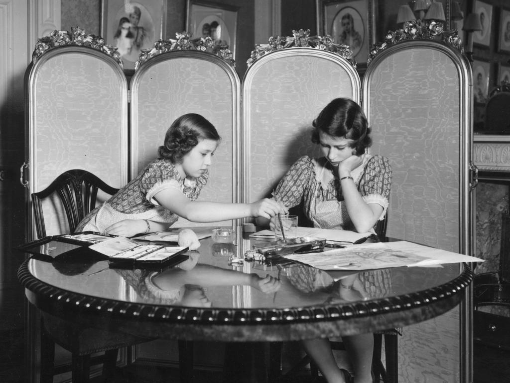 Margaret and Elizabeth work on paintings in the school room of Buckingham Palace. Their education was initially limited and supervised by their governess, but Elizabeth’s grandmother Queen Mary later stepped in to ensure she instructed in constitutional history by the vice provost of Eton, Henry Marten. Picture: Getty