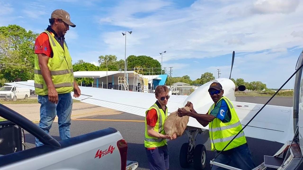 CEQ workers unpack a plane carrying supplies to stock the shelves of the ABIS supermarket in Kowanyama.