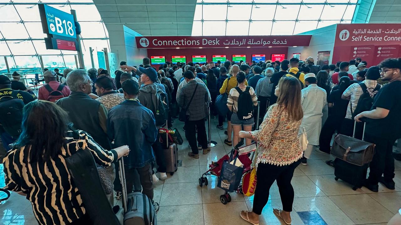 Passengers queue at a flight connection desk at the Dubai International Airport in Dubai on April 17 amid wild weather conditions causing delays. Picture: AFP
