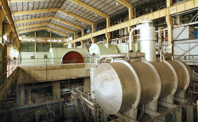 The giant, defunct coal-fired generator hall at Swanbank B. Its scale is demonstrated by a worker on the right. . Picture: David Nielsen