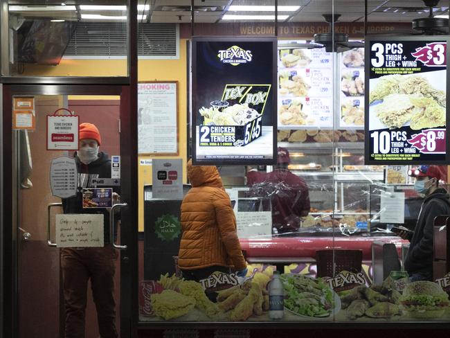 People wearing masks buy takeout food in the Brooklyn borough of New York. Picture: AP