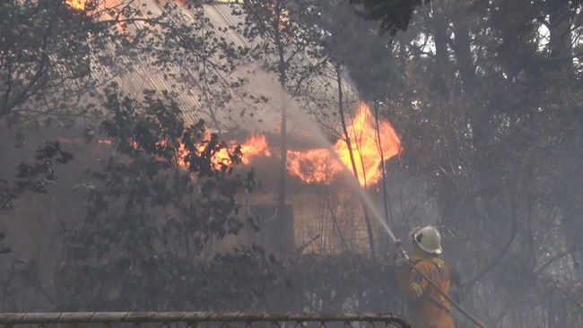 A firefighter tackles a blaze engulfing a home in Mt Wilson Picture: NSWRFS