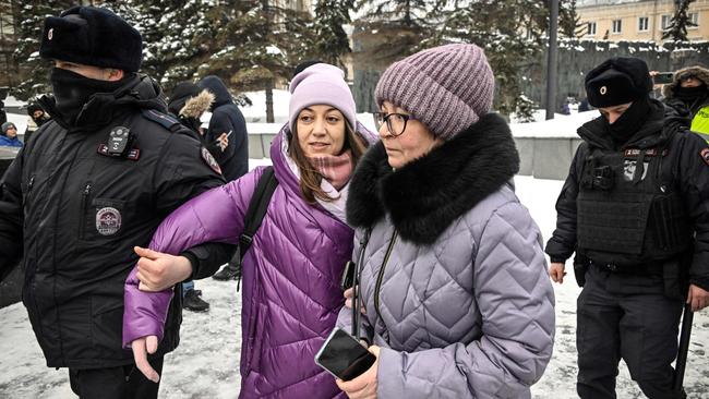 Police officers detain a woman as people come to lay flowers for late Russian opposition leader Alexei Navalny in Moscow. Picture: AFP