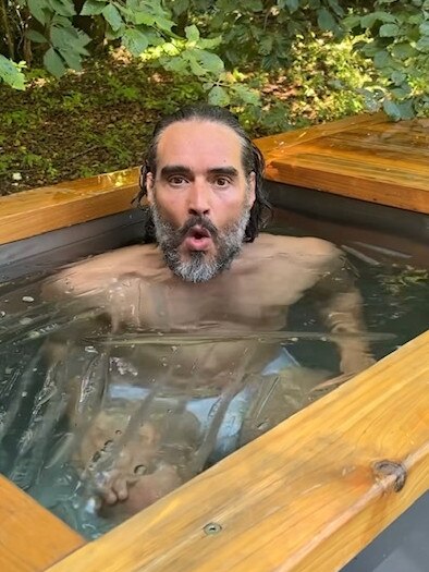 Russell Brand poses in a hot tub.