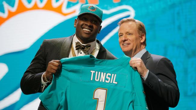Laremy Tunsil of Ole Miss holds up a jersey with NFL Commissioner Roger Goodell after being picked #13 overall by the Miami Dolphins.