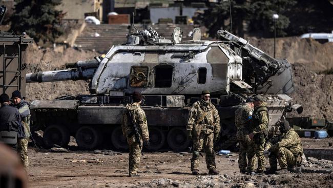 Ukrainian servicemen stand by a Russian army tank in Trostianets. Picture: AFP