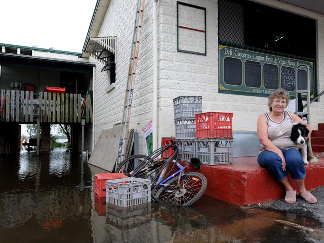 Diny McFarlane, former owner of the Lawrence General Store looks out over the rising flood water level from the steps of the shop. Pic: Dan Himbrechts