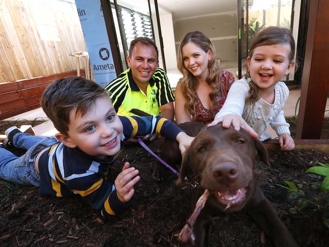 1/05/2020 : Steve and Sarah Kassiou, with their kids Liam 6 and Evelyn 4, and puppy Hazel, in a rear courtyard of a unit development they are building in Clayfield, Brisbane. A builder by trade, Steve is undertaking the remodel of a pre-war Queenslander in the inner-city Brisbane suburb of Clayfield into townhouses which he hopes to sell when the market turns post-COVID. Lyndon Mechielsen/The Australia