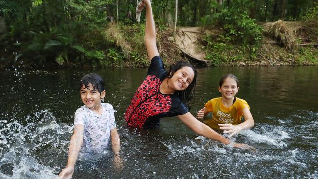 The hot, humid weather that Cairns has been experiencing will make way for rain this week. Cousins Sofia Drandic, 10, Kamani Maz, 8, and Samara Maza, 10, cool down from the heat with a swim in Freshwater Creek at Goomboora Park after school. Picture: Brendan Radke