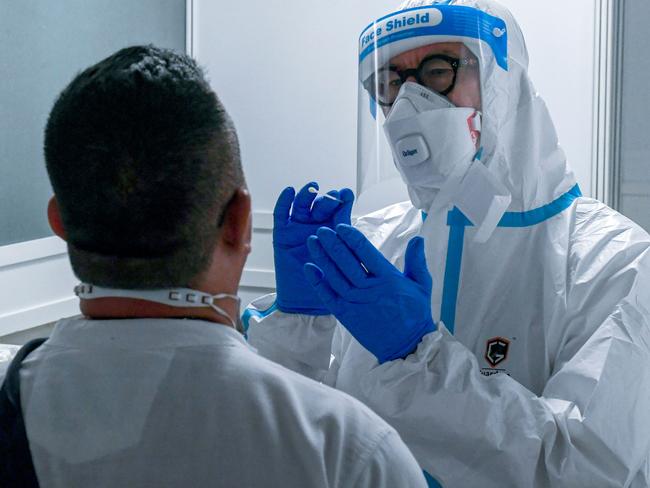 A passenger is tested by a doctor at a corona screening station in the medical center of the airport in Duesseldorf, western Germany, on July 27, 2020, amid the new coronavirus COVID-19 pandemic. - The state government is setting up test centres for the corona virus at four North Rhine-Westphalian airports for passengers returning from high-risk areas. (Photo by Ina FASSBENDER / AFP)