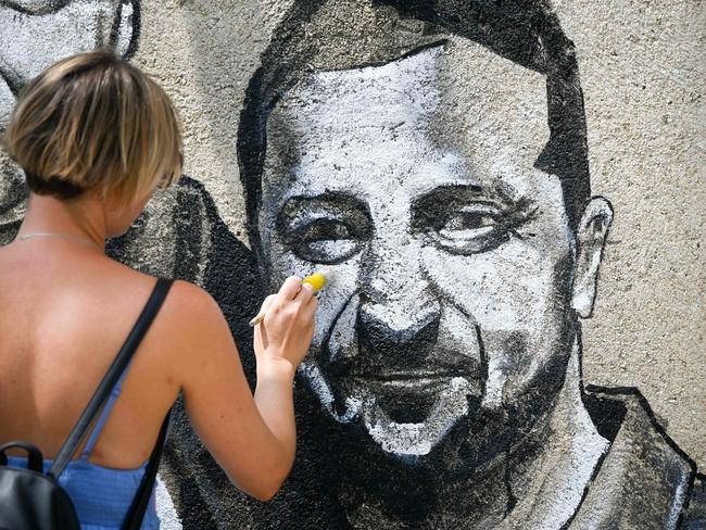 An artist paints a mural of the President of Ukraine Volodymir Zelenskyy on a wall. Picture: AFP