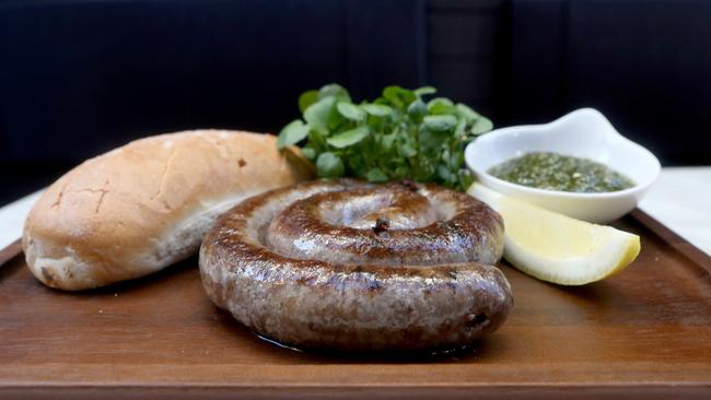 Boerewors sausage over charcoal served with crusty bread and chimichurri sauce from Burnt Ends Kitchen and Bar. Picture: AAP/Steve Pohlner