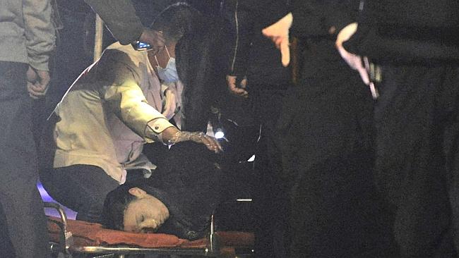 A victim ... is inspected by police officers. Picture: AP.