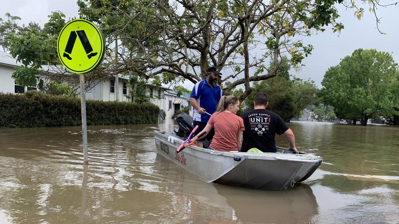 Max Walker paddles for Steve and Bianca Bennett after taking them to their flooded Hunter Street home on Tuesday, a day after Lismore was hit by a record flood. Picture: Stuart Cumming