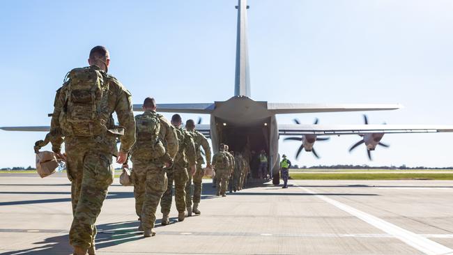 Members of the 1st Armoured Regiment, 1st Brigade board a C-130J Hercules.