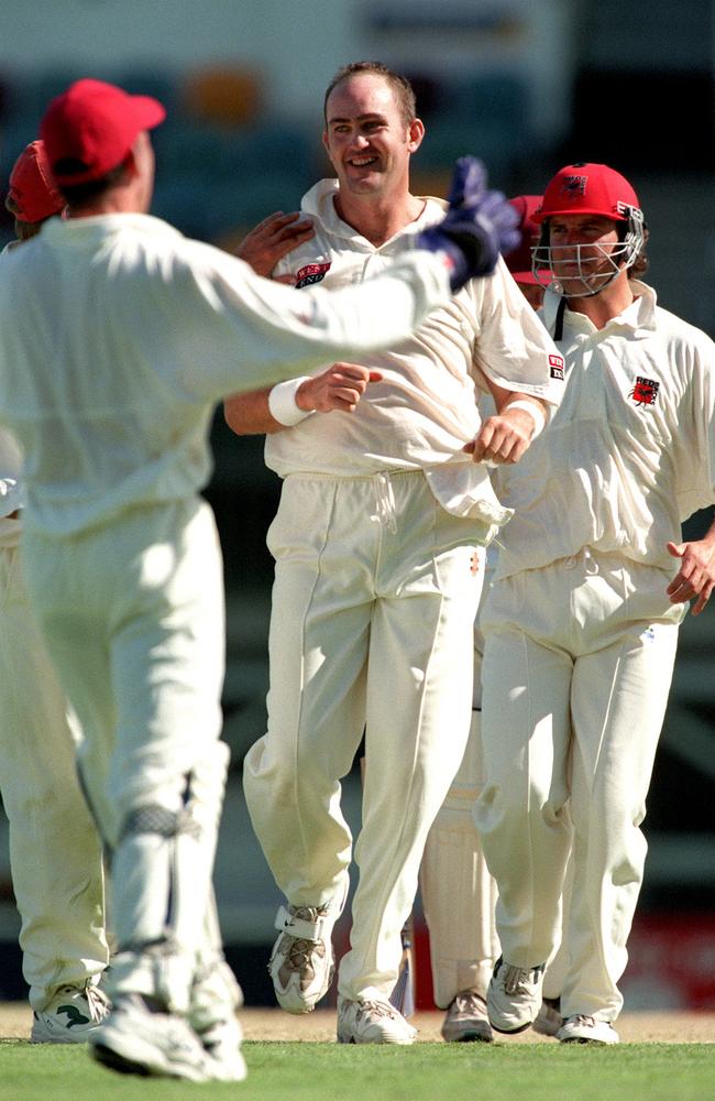 South Australia’s Brad Wigney being congratulated by teammates after taking wicket against Queensland at the Gabba in 1998.