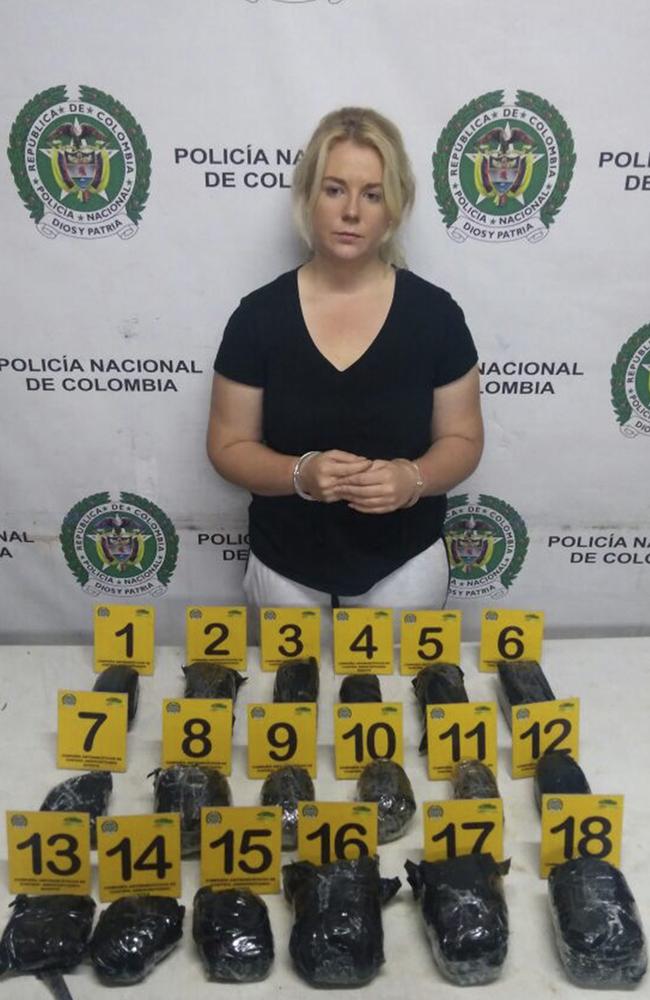 South Australian drug mule Cassandra Sainsbury handcuffed and posing with the cocaine packages from her suitcase. Picture: Colombian National Police