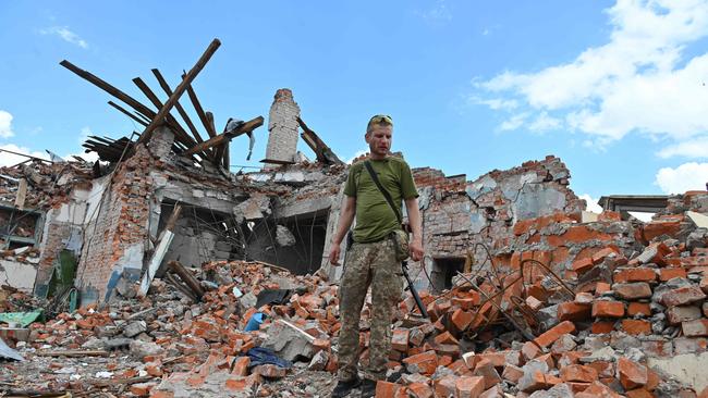 A Ukrainian serviceman inspects the ruins of Lyceum building, suspected to have been destroyed after a missile strike near Kharkiv on July 5.