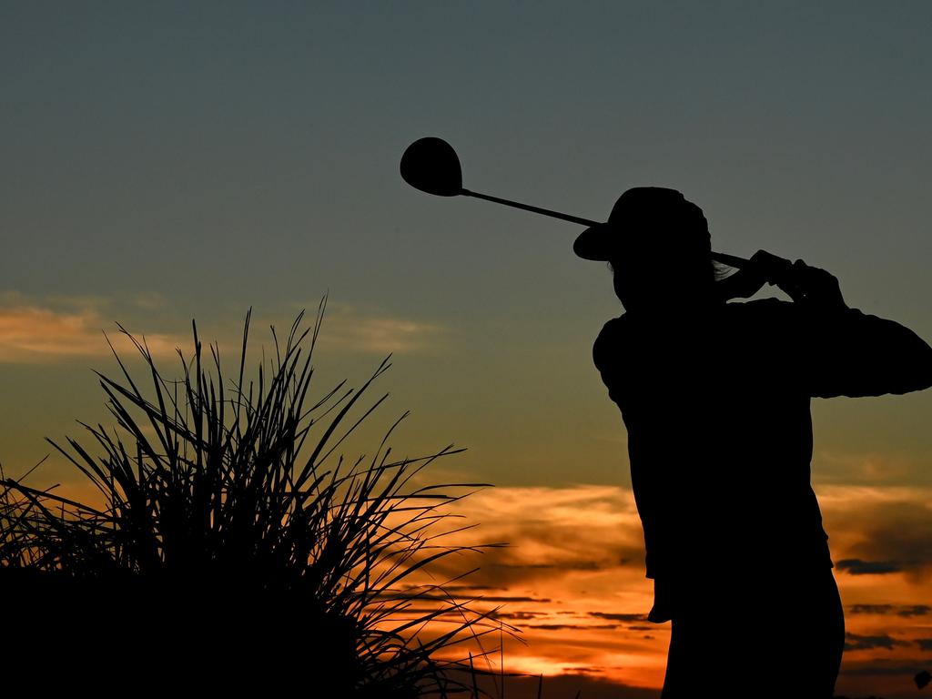 A golfer practises her swing late on Tuesday before the reopening of golf courses in Melbourne. Picture: Getty