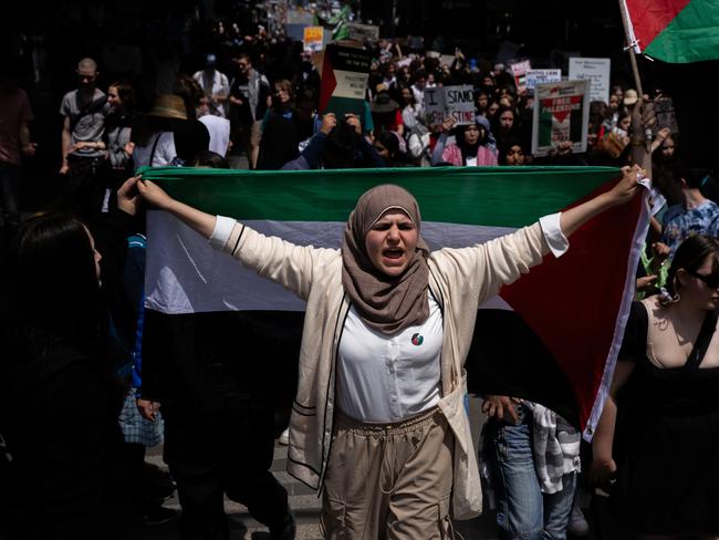 A protester holds a Palestinian flag and chantings during the demonstration in Melbourne.