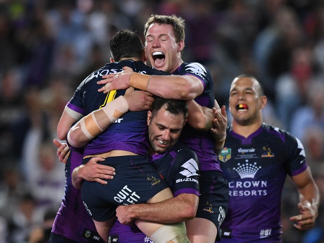 Billy Slater of the Storm is lifted by teammate Cameron Smith as he celebrates scoring a try during the NRL grand final between the Melbourne Storm and the North Queensland Cowboys at ANZ Stadium in Sydney, Sunday, October 1, 2017. (AAP Image/David Moir) NO ARCHIVING, EDITORIAL USE ONLY