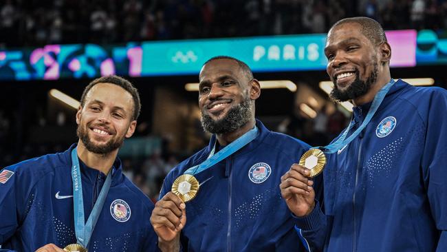 Steph Curry, LeBron James and Kevin Durant with their gold medals in Paris. (Photo by Damien MEYER / AFP)