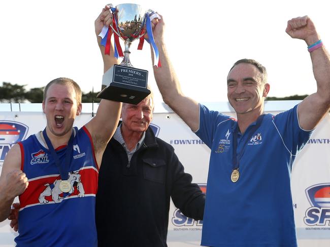 Kieran Knox and coach Jason Heffernan raise the premiership cup.