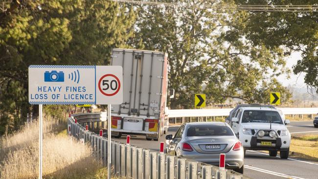 Vehicles drive past a notification for the Ulmarra speed cameras.