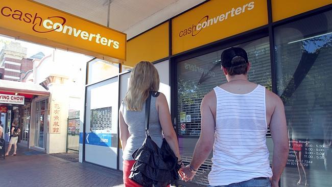 Young couple standing in front of closed Cash Converters store on Gouger Street, Adelaide.