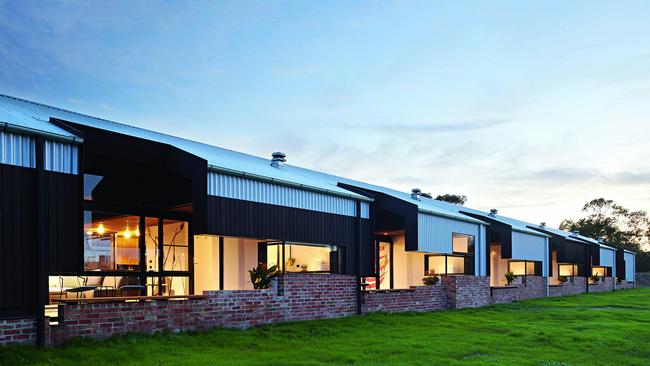 The luxury suites, clad in shearing shed iron, brick and timber, are tucked behind a raised garden. Picture: Colin Page