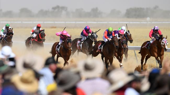 Crowds watch a race at the Birdsville Races in Birdsville, Queensland, in 2019. (AAP Image/Dan Peled).