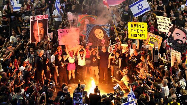 Demonstrators light a fire and hold placards and flags during an anti-government protest in Tel Aviv on September 21, 2024. Picture: Jack Guez/AFP