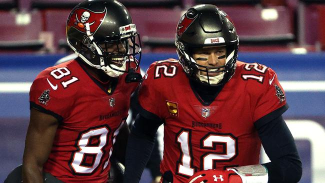 Quarterback Tom Brady #12 of the Tampa Bay Buccaneers congratulates wide receiver Antonio Brown #81 after a touchdown during the 1st quarter of the game against the Washington Football Team at FedExField on January 09, 2021 in Landover, Maryland. (Photo by Patrick Smith/Getty Images)