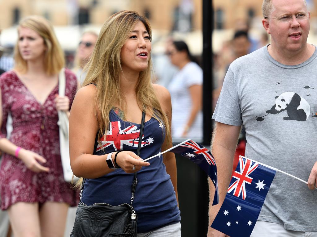 People wearing Australian flag clothing watch the Ferrython race on Sydney Harbour during Australia Day celebrations in in Sydney. Picture: AAP Image/Brendan Esposito