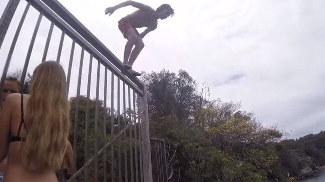 A child jumping off a fence ledge on the top rock platform at Jump Rock, Collins Beach. Picture: YouTube.