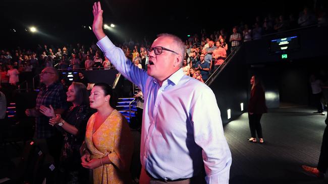 Eyes closed, hand raised, Scott Morrison – next to wife Jenny – sings along to <i>Glorious Day</i> at Horizon Church in Sutherland, Sydney, yesterday morning. Picture: Gary Ramage