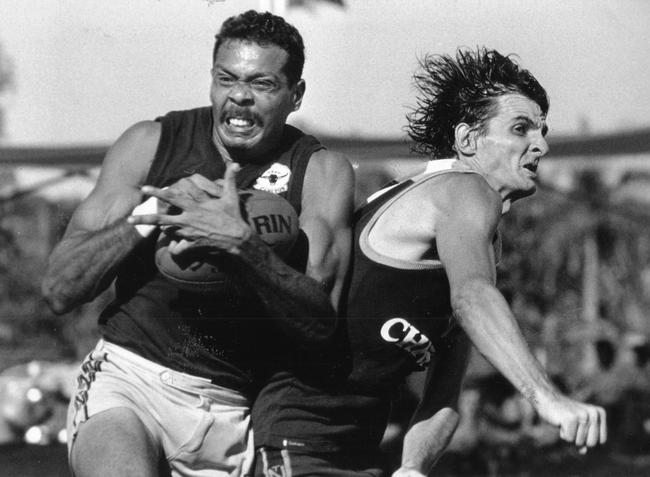 Dennis Dunn playing for St Mary's the ball before Darwin's David Atkinson can punch it out of his reach during an NTFL match at the Gardens Oval in 1994.