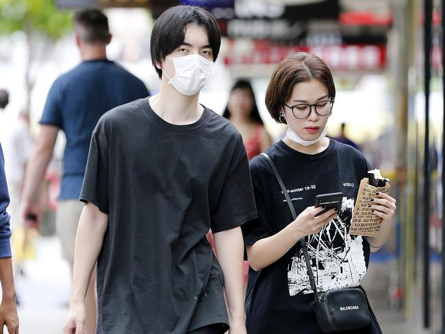 Pedestrians pictured in Brisbane CBD wearing masks.