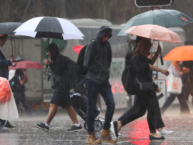 Daily Telegraph March 27/3/23. Commuters caught out in the occasional heavy showers in the City .picture John Grainger