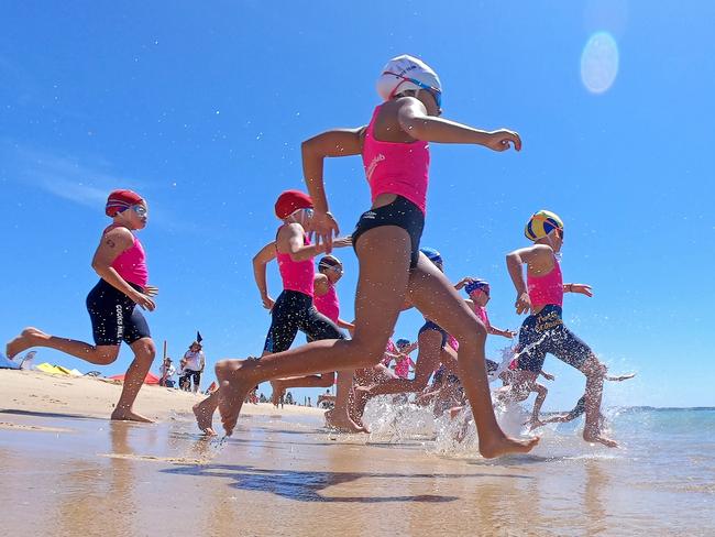 EXPRESS ADVOCATE/AAP. Competitors hit the water during the final of the U10 Female Surf Race of the NSW Surf Life Saving Championships at Blacksmiths Beach at Blacksmith on Friday, 28 February, 2020. (AAP IMAGE / Troy Snook)